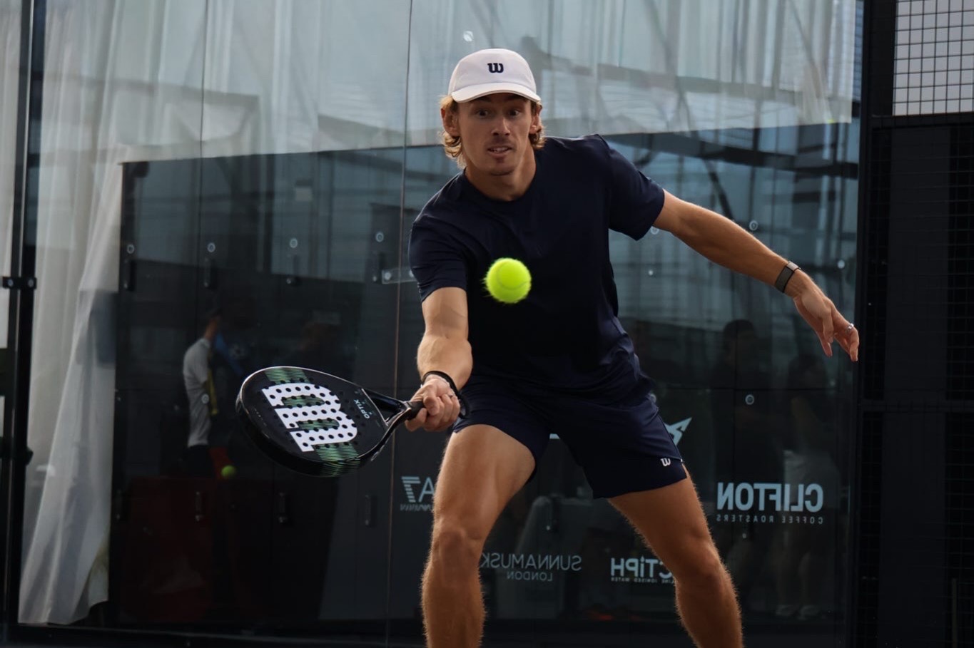 A member playing a forehand during a club tournament