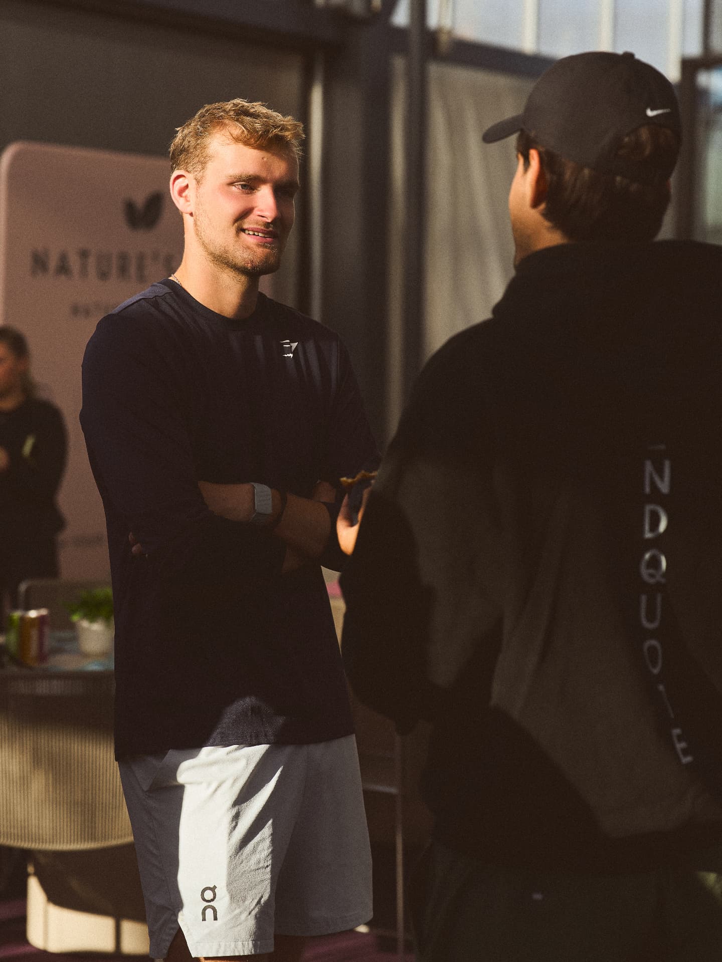 A member smiling with his racket at a Stakes Club event