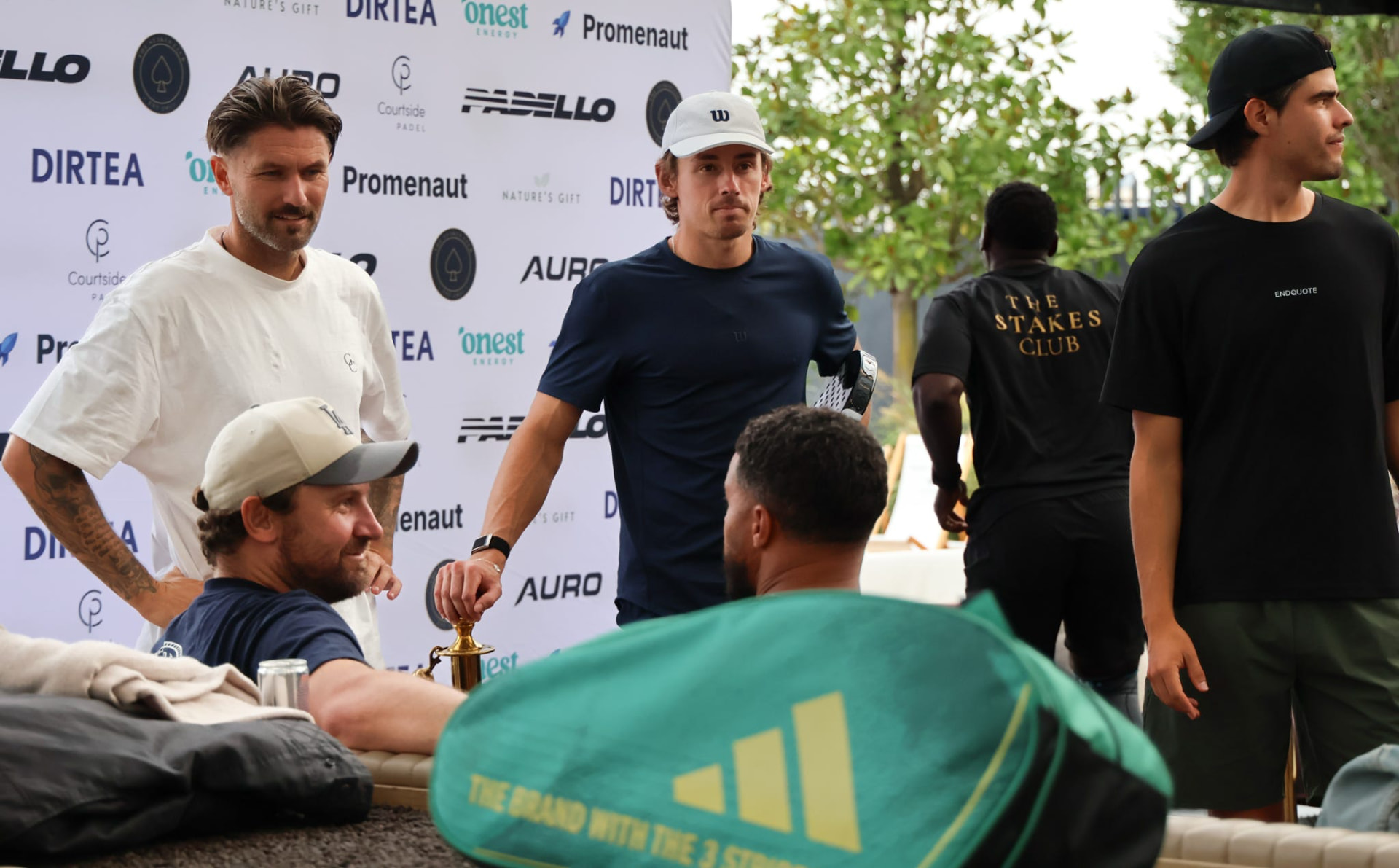 Players and members in front of the sponsor wall at a club tournament