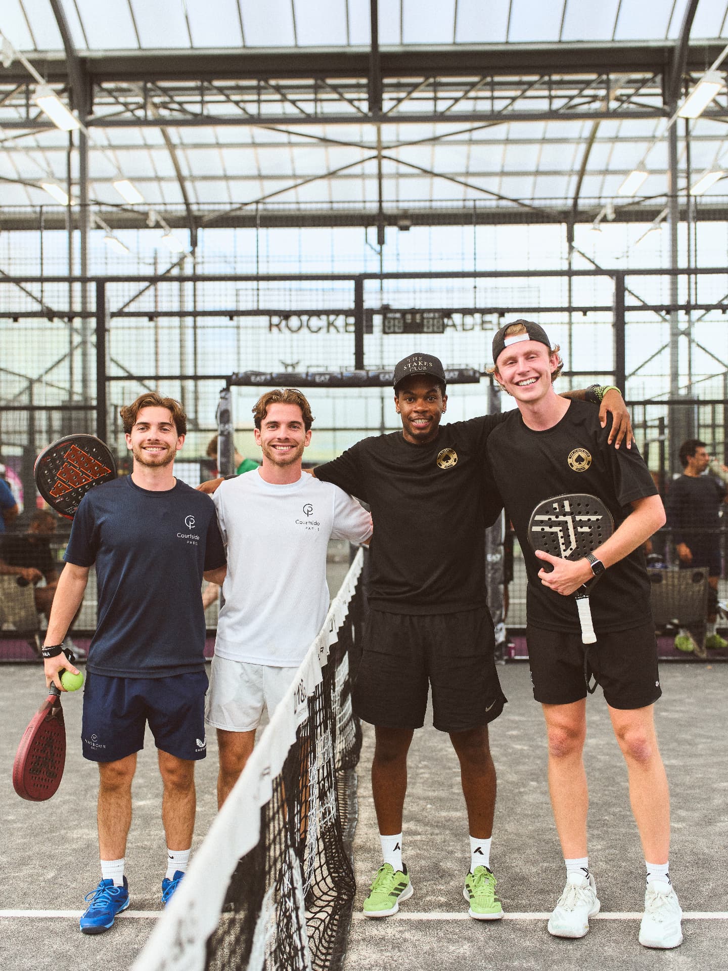 Four players posing together at the net after a Stakes Club match
