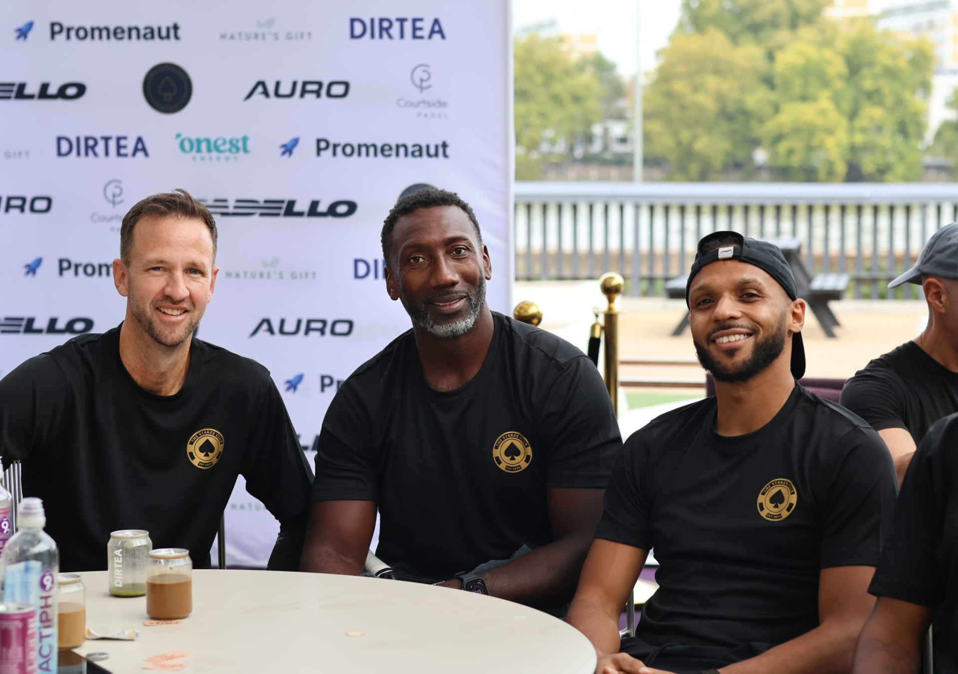 Three members in club shirts seated at an event table